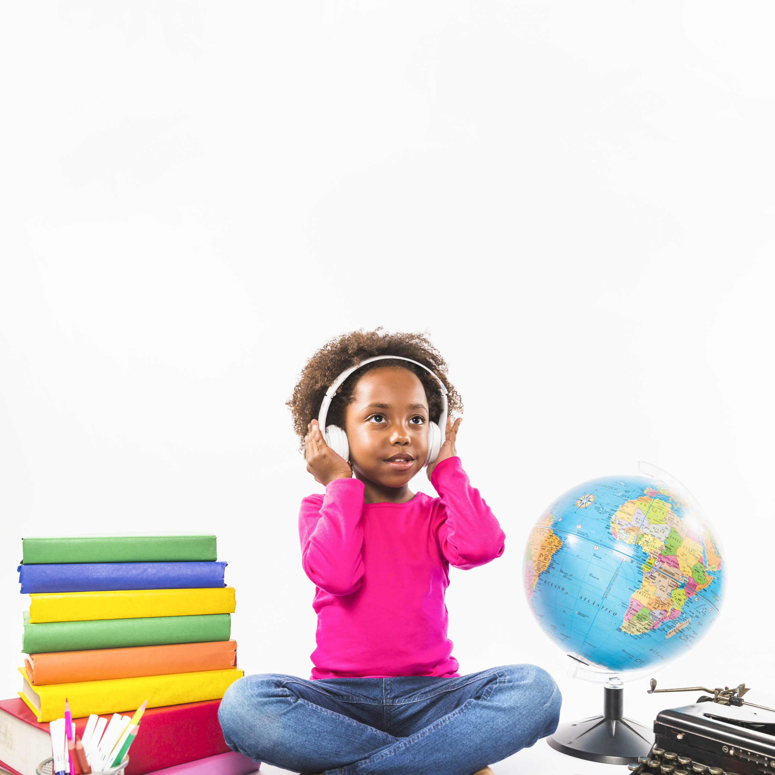 fille dans les ecouteurs pres de livres et globe en studio scaled